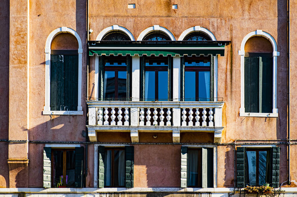 Italian culture on Venetian facades. Venice is rich and poor, well-groomed and abandoned, reflected in its windows. - Foto, immagini