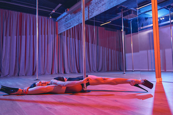 Sexy female dancer doing the split in pole dance studio - Φωτογραφία, εικόνα