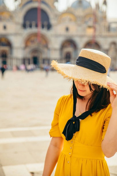 woman in yellow sundress outdoors hiding eyes behind big straw hat fashion concept - Photo, Image