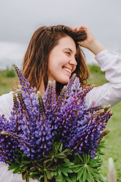 woman at blooming lupines field. enjoying the moment - Photo, Image