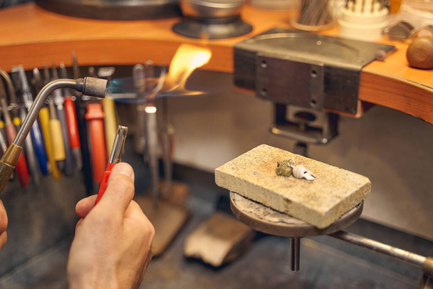 Skilled worker preparing a fuel-burning tool for metalworking - Фото, изображение