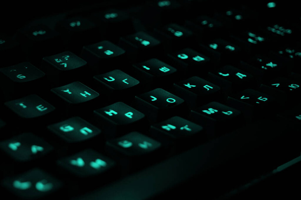 Backlit tastiera da gioco da vicino. Tasti neri con caratteri blu illuminati. - Foto, immagini