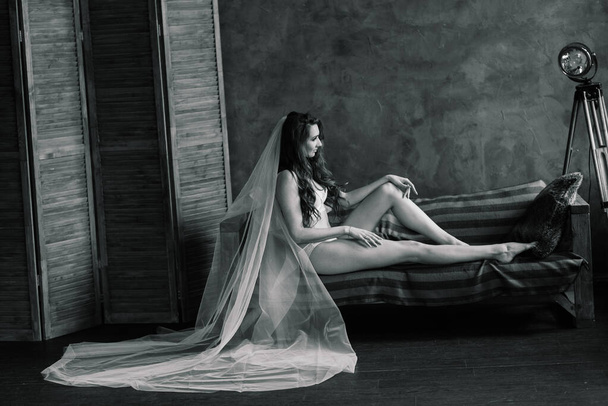 Πρωί της νύφης. Σέξι κοπέλα που ποζάρει με δαντελένια εσώρουχα. Πορτραίτο μιας όμορφης νεαρής γυναίκας με λευκό εσώρουχο. Δελεαστικό θηλυκό σε λευκό λινό και peignoir. - Φωτογραφία, εικόνα