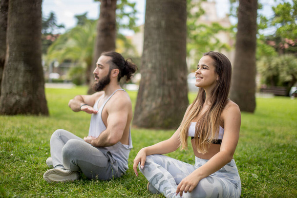 Young couple doing yoga outdoors - Zdjęcie, obraz