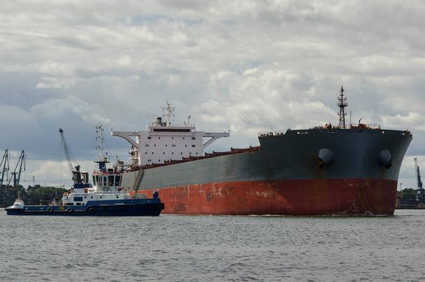 TRANSPORTADOR DE BULK - Un buque mercante zarpa del puerto en un crucero hacia el mar - Foto, Imagen