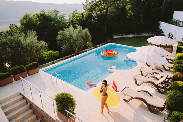 hermosa mujer relajarse en la piscina inflable juguete unicornio en la piscina
 - Foto, imagen