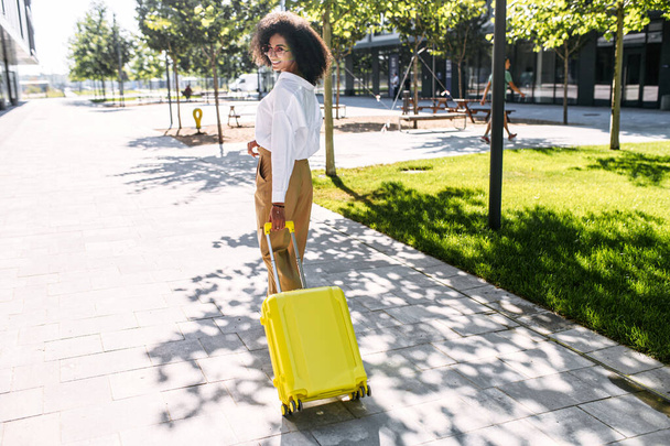 A beautiful woman with a suitcase outdoors - Fotoğraf, Görsel