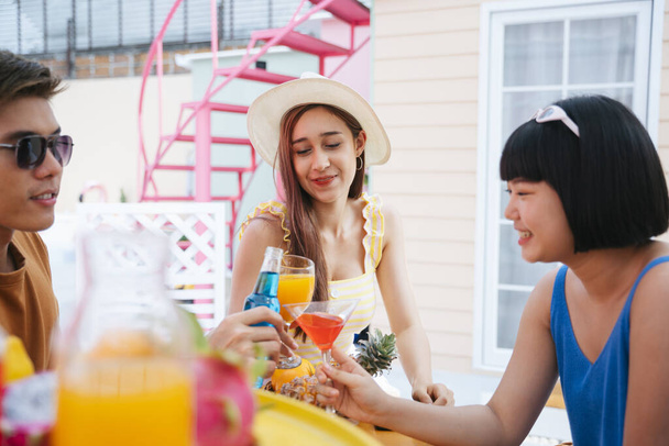 美しいアジアの女性は夏に熱帯のバーで人々と飲むのを楽しむ. - 写真・画像