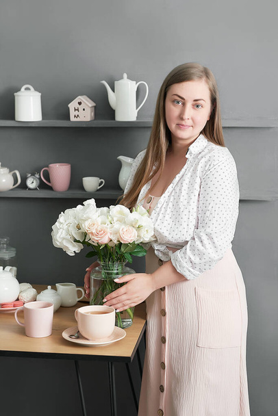 Florist woman. Floral background. Flower shop interior. Floral design studio, making decorations and arrangements. Flowers delivery service and sale of home plant, creating order. Peonies and roses. - Foto, Bild