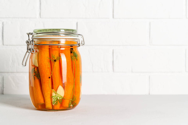 Terveellistä probioottista vegaaniruokaa. Kotitekoinen fermentoitu porkkanat valkosipuli, tilli ja pippuri lasipurkissa. - Valokuva, kuva