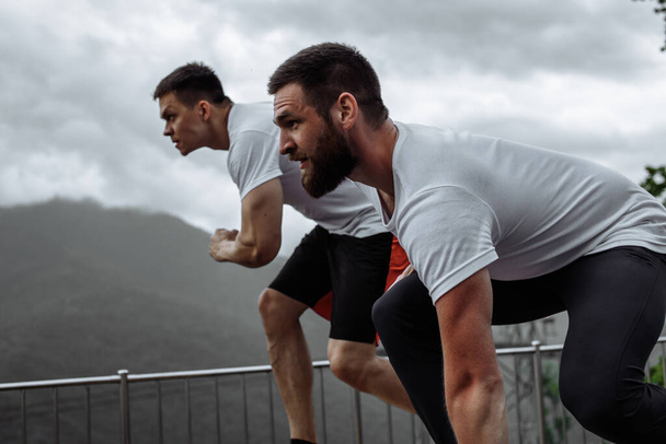 Ochtendtraining, sportieve mannen rennen in de bergen leven een gezonde levensstijl - Foto, afbeelding