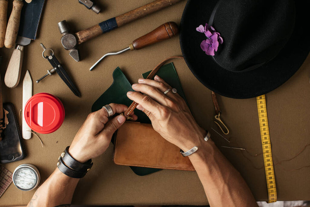 Close up of skinner craftsman working with natural leather using craft tools. - Valokuva, kuva