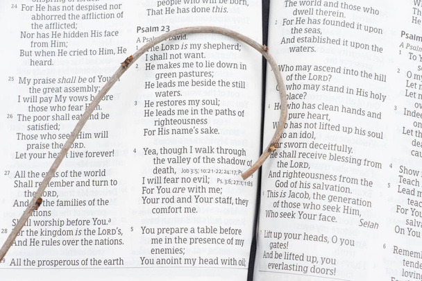 A Bíblia Sagrada abriu no Salmo 23 com um pequeno cajado em cima. Versos 1 a 5. Close-up. Tiro horizontal
. - Foto, Imagem