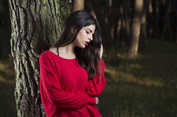 Portret van jonge mooie vrouw met lang haar buiten in het bos - Foto, afbeelding