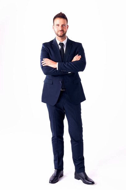 Full length shot of smiling businessman wearing suit while standing with arms crossed at isolated white background. Copy space. - Fotoğraf, Görsel