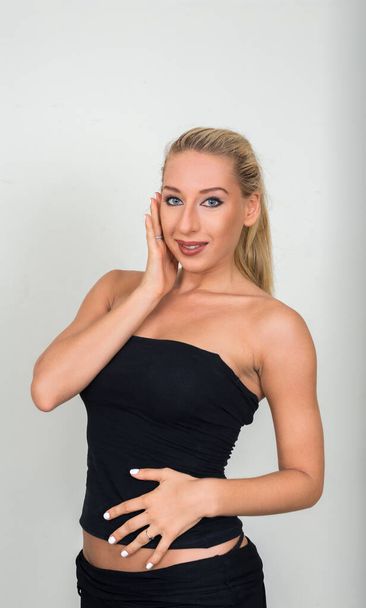 Studio shot of young beautiful blonde woman against gray background - Photo, Image