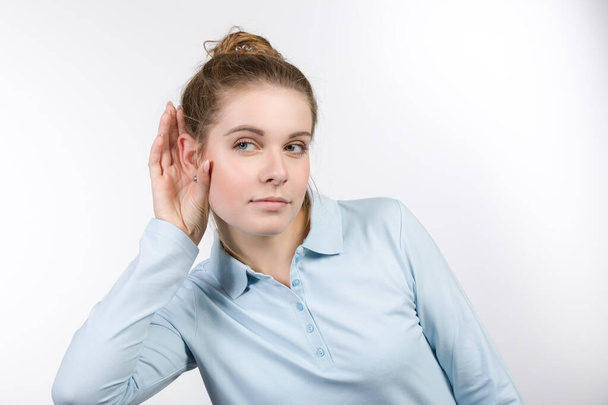 Молода жінка з рукою на вухо намагається слухати краще
 - Фото, зображення