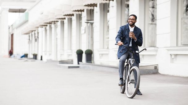 Bonito empresário afro andando de bicicleta bebendo chá
 - Foto, Imagem