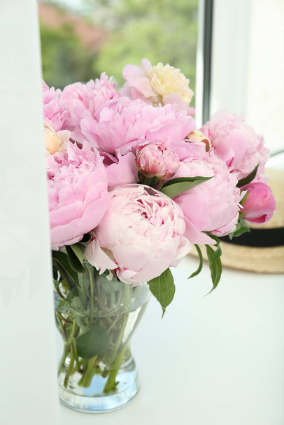 Bouquet of beautiful peonies in vase on window sill - Foto, Imagen