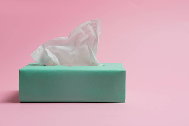 Box with paper tissues on pink background - Foto, imagen