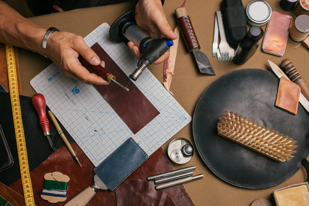 Close up of a shoemaker working with leather sample and hammer at workshop - Foto, Imagem