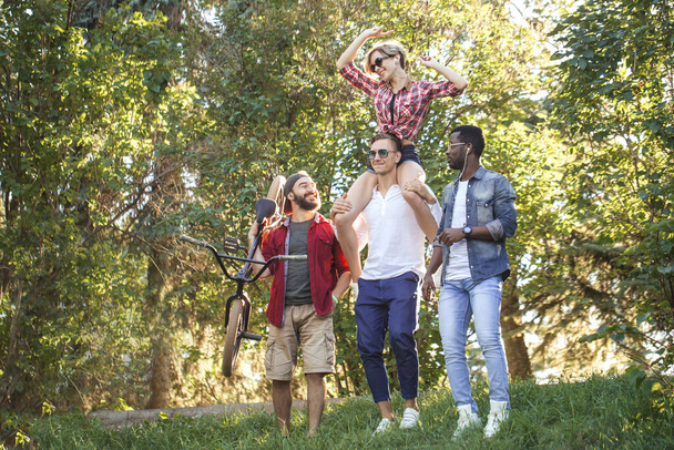 Beste multiraciale vrienden samen rondhangen en wandelen in het park in de zomerdag. - Foto, afbeelding
