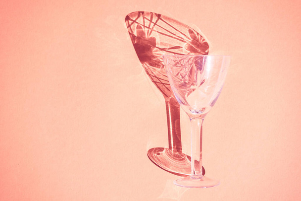 Beautiful abstract background wine glass light rays refracting, coral pastel color background, abstract design bright fun flat lay, light through glass shadow on colorful backdrop. - 写真・画像