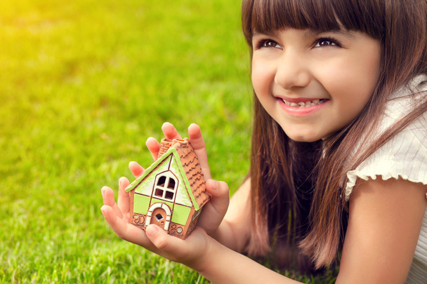 портрет маленької дівчинки з будинком в руці на тлі
 - Фото, зображення