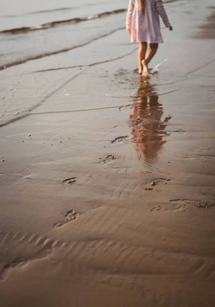 child runs on the beach sunset - Photo, Image