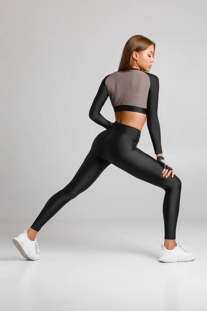 Sexy fitness žena. Krásná atletická dívka, izolované na šedém pozadí - Fotografie, Obrázek