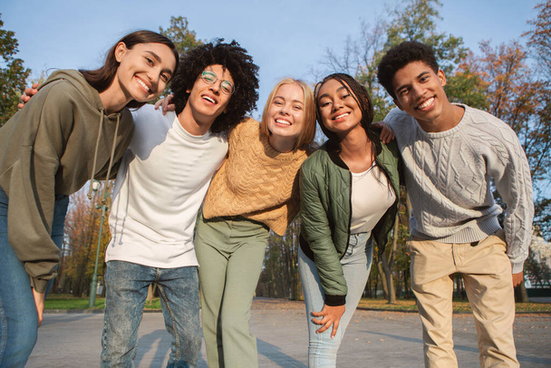 Divertidos adolescentes multiétnicos sonriendo a la cámara al aire libre - Foto, imagen