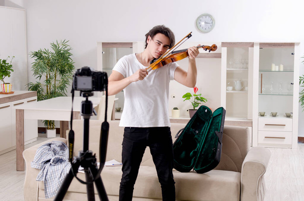 Молодой блогер играет дома на скрипке - Фото, изображение