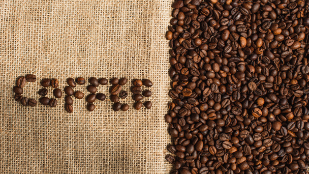 Ansicht von Kaffee-Schriftzug aus Bohnen auf Sacktuch - Foto, Bild