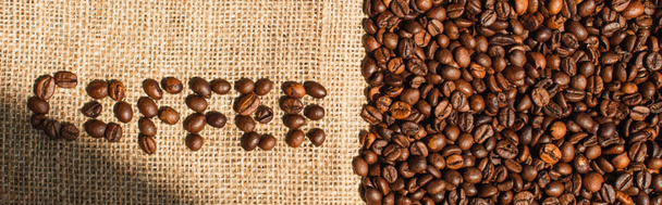 top view of coffee lettering made of beans in sunlight on sackcloth, panoramic shot - Fotoğraf, Görsel