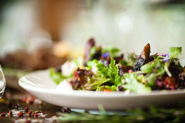 Verse veganistische salade. Avocado, couscous, meloen, portobello, soja, tofu op wit bord. Heerlijke gezonde gemengde greens voedsel closeup geserveerd op een tafel voor de lunch in de moderne keuken gastronomisch restaurant. - Foto, afbeelding