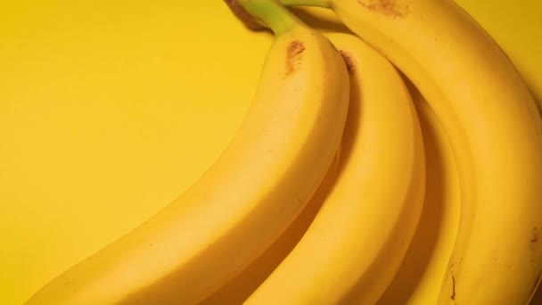 свежие бананы на жёлтом минималистичном фоне - Кадры, видео