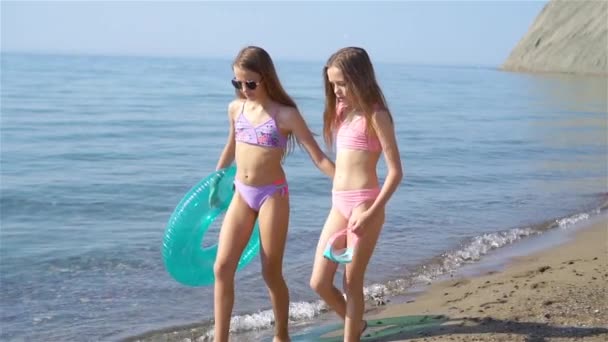 Μικρά χαρούμενα αστεία κορίτσια διασκεδάζουν πολύ στην τροπική παραλία παίζοντας μαζί.. - Πλάνα, βίντεο