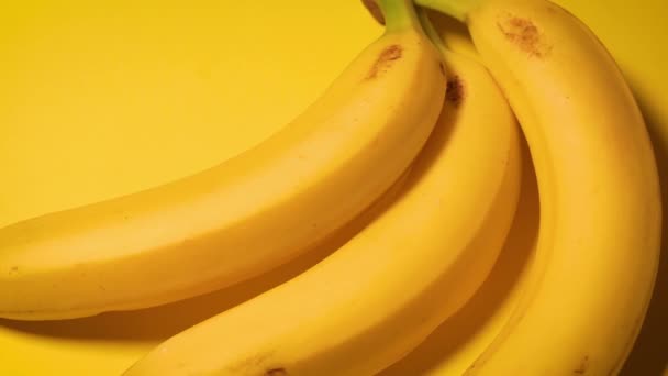 свежие бананы на жёлтом минималистичном фоне - Кадры, видео