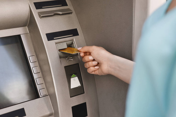 ATM機にクレジットカードを挿入する女性の手の閉じる - 写真・画像