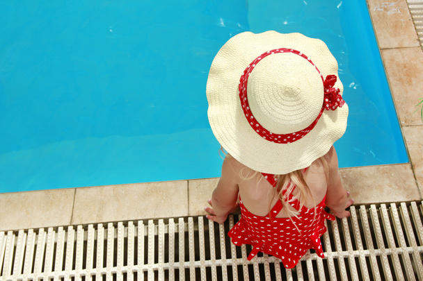 little girl in a hat floating in the pool - Foto, imagen