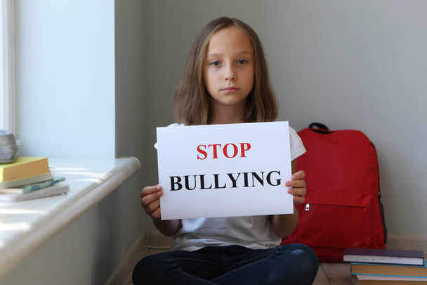Menina triste segurando um sinal de bullying stop
 - Foto, Imagem
