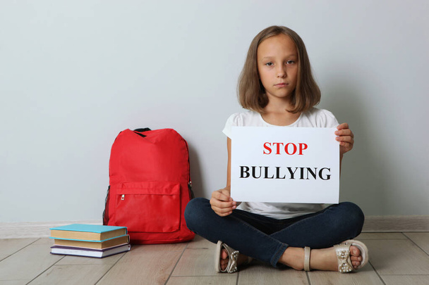 Menina triste segurando um sinal de bullying stop
 - Foto, Imagem