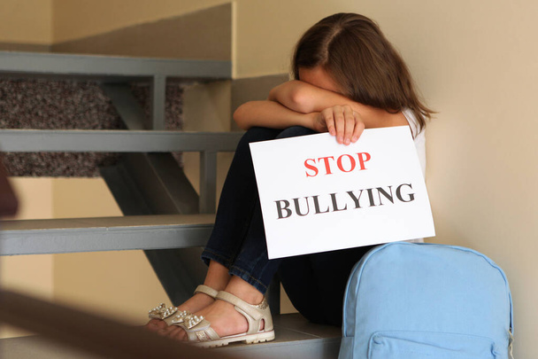 Sad girl holding a stop bullying sign - Photo, Image