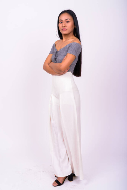 Studio shot of young beautiful Asian woman against lilac background - Foto, immagini