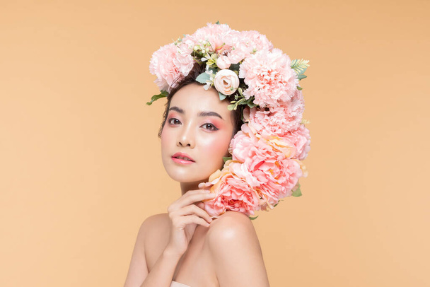 Piękno Azji młoda kobieta z dużymi kwiatami bukiet na twarzy uśmiech z czystej świeżej skóry Szczęście i wesoły z pozytywnymi emocjami na beżowym tle, Kosmetyki uroda i leczenie twarzy Concept - Zdjęcie, obraz