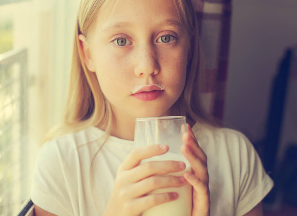 Roztomilá holka pije čerstvé organické mléko. Zdravá výživa pro malé děti - Fotografie, Obrázek