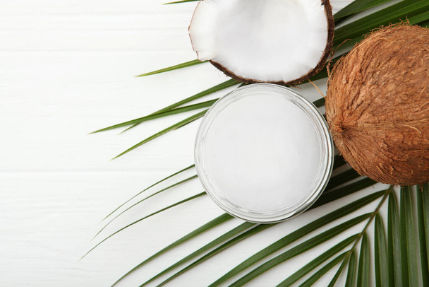 кокосовое масло и кокосы на столе - Фото, изображение