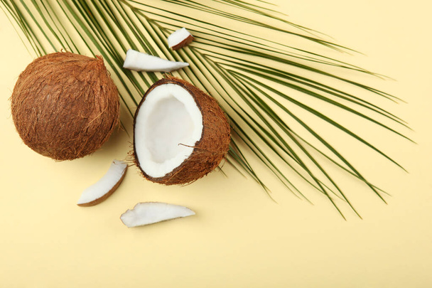 gebroken kokosnoot op een gekleurde achtergrond. - Foto, afbeelding