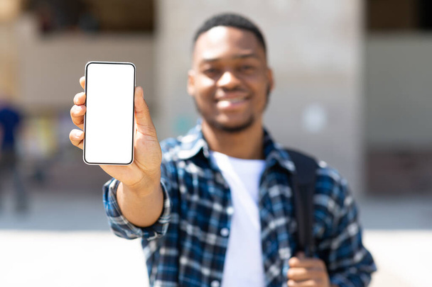 Afro hombre mostrando pantalla de teléfono móvil en blanco - Foto, imagen