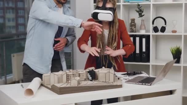 Attractive high-skilled concentrated 35s successful designers working with wooden model of buildings applying special 3d glasses in modern design studio - Video, Çekim